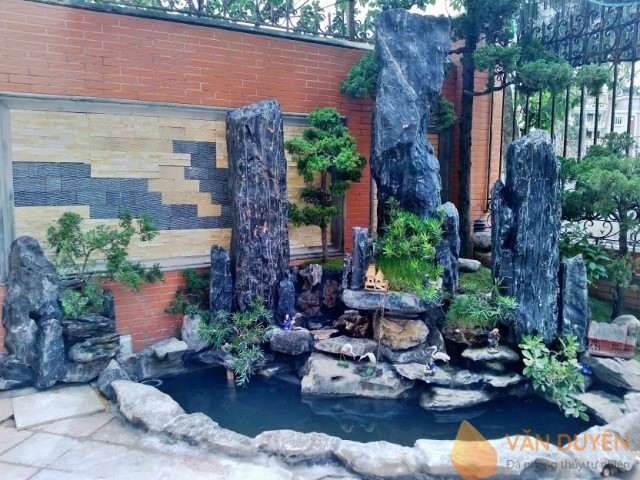 Cụm đá cảnh tối màu kết hợp hồ nước và cây xanh, linh hoạt và hài hòa tổng thể sân vườn.