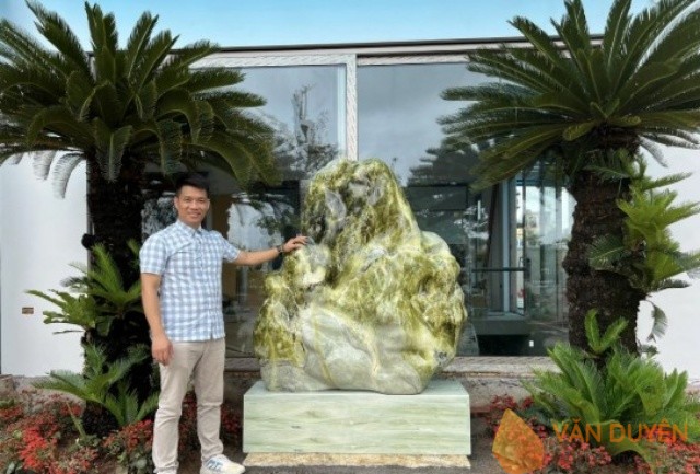 Khối đá cảnh lớn đặt trên bệ thấp, bố trí lệch trục cửa và kết hợp mảng cây xanh, giúp dễ áp dụng theo mệnh – đẹp, rõ ràng và an toàn trong sử dụng lâu dài.